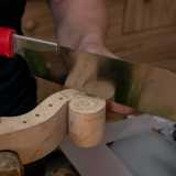 Posizionata anche la catena (un listello che distribuisce la pressione generata dalle corde tese), si passa al manico e al suo riccio. Dopo aver piallato, contornato e tagliato un pezzo di acero...
